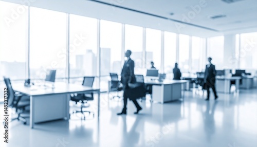 A softly blurred office interior with neutral tones and open-plan desks creates a clean, modern corporate atmosphere. Natural light streams through large windows.