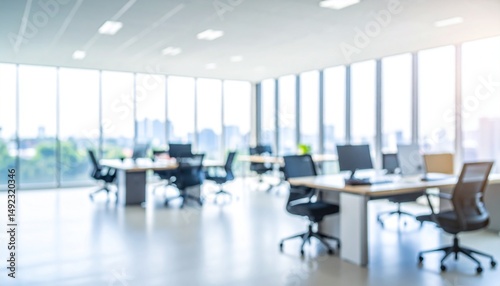 A softly blurred office interior with neutral tones and open-plan desks creates a clean, modern corporate atmosphere. Natural light streams through large windows.