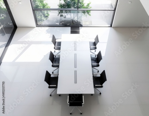 Modern conference room with wooden table and black chairs illuminated by natural light