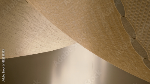 Elegant close-up of woven textile structures in natural light—minimalist abstract photo highlighting textures, patterns, and shadows in a soft neutral tone for design inspiration and artistic mood