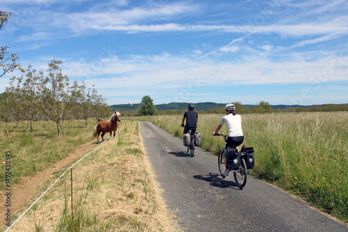 Tourisme balade à vélo, cyclistes dans un paysage pittoresque de campagne