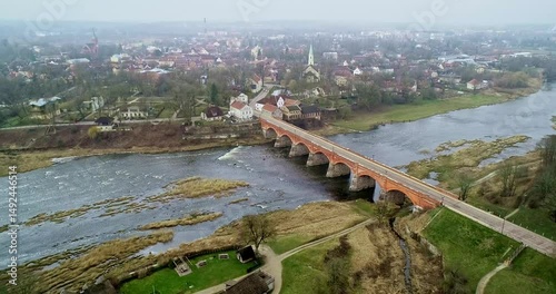 A breathtaking Aerial View of the Bridge Over the Serene River showcasing its stunning beauty Kuldiga Latvia