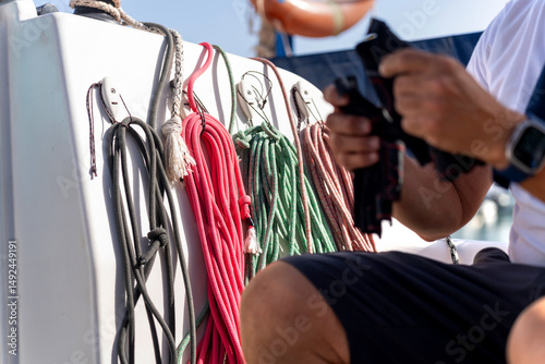 Sailor preparing sailing ropes on a sailboat during navigation