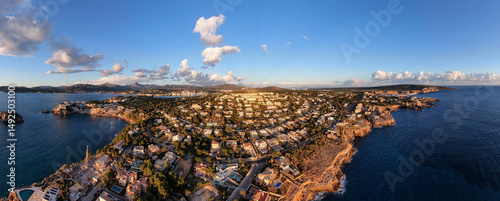 Coastal town residential area stunning aerial panoramic photo surrounded by the sea sunlight illuminate building golden hour