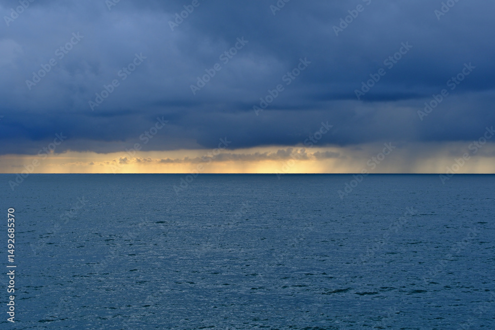 Obraz premium Stormy Sea Horizon with Rain and Dramatic Clouds