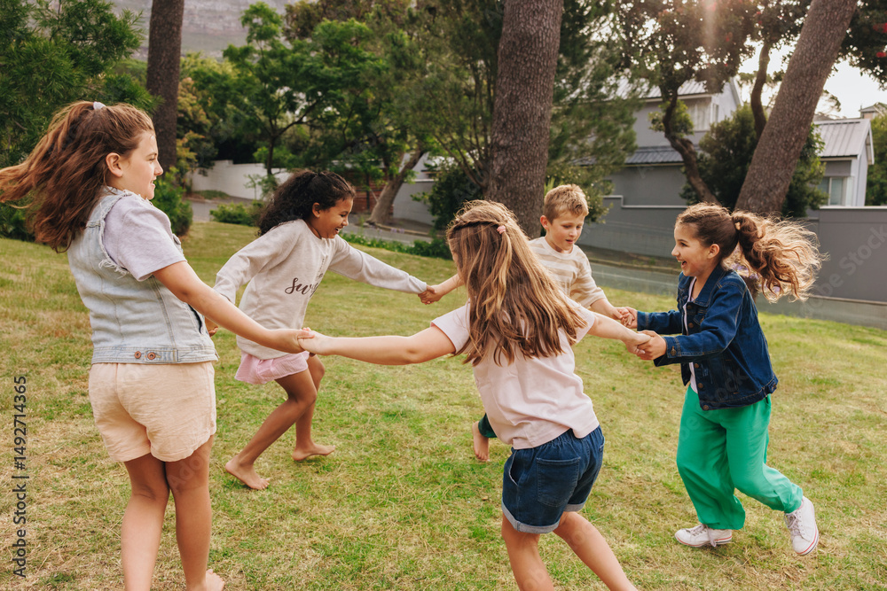 Fototapeta premium Children playing together in a grassy park during a sunny day