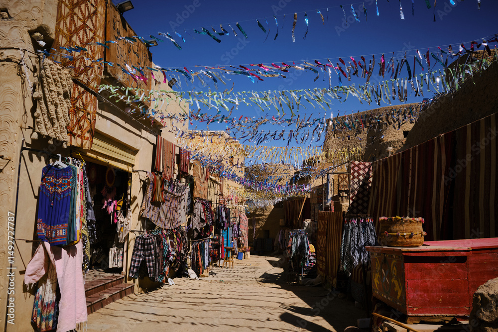 Obraz premium Traditional berber clothes and souvenirs on the souk in Shali fortress. Street bazaar at Siwa oasis, Sahara desert, Egypt