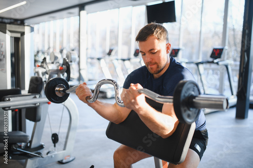 Determined male athlete lifting weights in a modern gym for rehabilitation and recovery