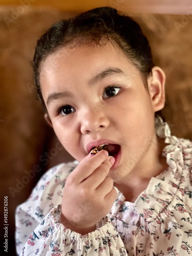 Portrait of a little girl eating sweet food