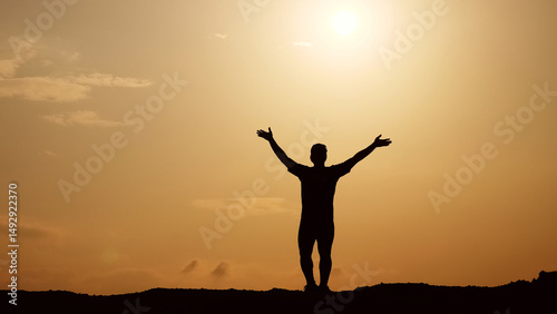 Wallpaper Mural Silhouette of Freedom: A solitary figure raises arms towards the sun, embodying freedom, joy, and a deep connection with nature against the golden embrace of the sunset. Torontodigital.ca