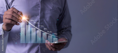 Young man with smartphone hand touching to visualize money growth The phone screen displays graphs and charts showing increasing investment and savings trends, along with an increased account balance