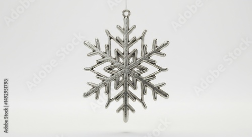 Elegant silver snowflake ornament hangs delicately against a bright white background. AI Generated