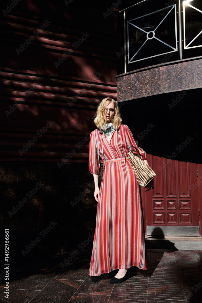 Naklejka premium street style fashion girl model in red dress on the street.