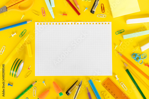 Back to school concept Photo of Items for school student gear around white paper over yellow background