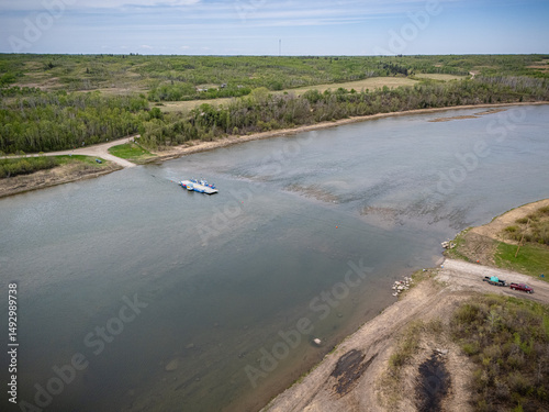 Boat is floating on a river near a grassy area