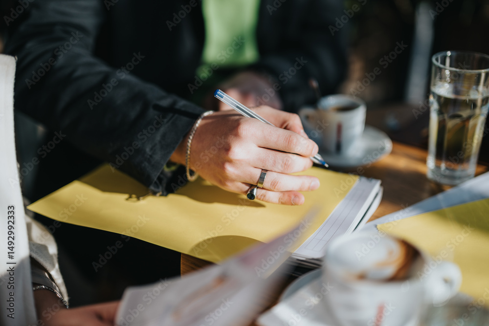 Fototapeta premium A team working outdoors engages in creative collaboration, note-taking, and networking while enjoying coffee. The setting highlights productivity and casual teamwork in an inspiring and relaxed area.