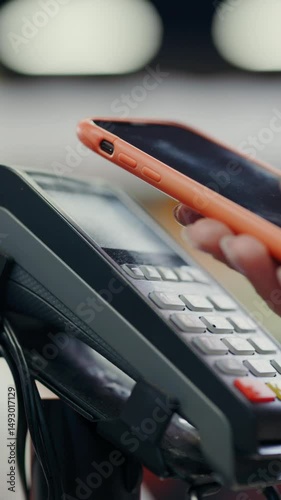 Close-up of woman fem ale customer hand putting smartphone touching terminal payment scanning nfc technology contactless payment wireless device concept. Supermarket.