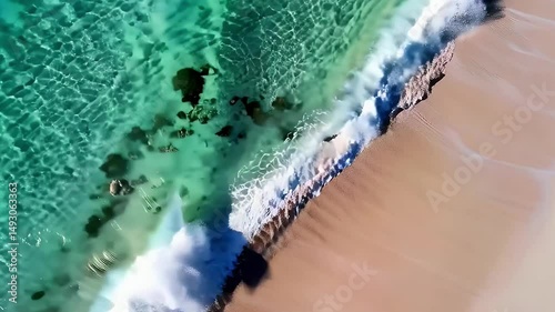 aerial view of gentle sea waves caressing the sandy shore