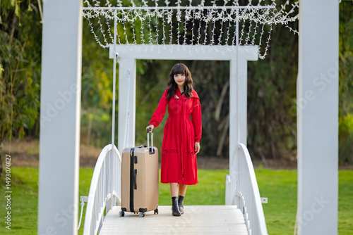 Cheerful passenger asian woman with travel suitcase going to travel on holidays. Looking camera and Smile