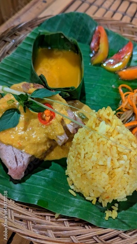 Fresh tuna steak with rice and pumpkin soup in banana leaf cuisine in Bali Indonesia