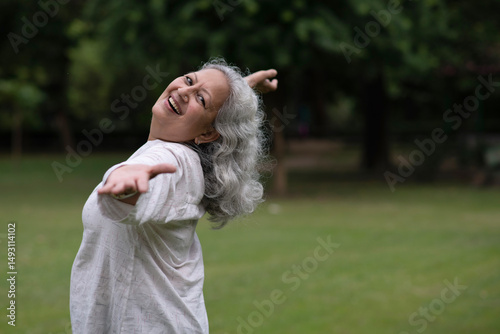 Foto Indian happy senior woman spread her arms in environment nature like the wings of a bird