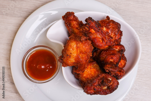 Alette di pollo fritte piccanti servite in una braceria accompagnate da salsa bbq