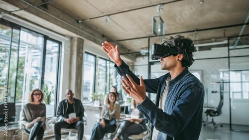 Man Demonstrating Virtual Reality Technology to a Diverse Group of Coworkers in a Modern Office Setting With Concrete Walls and Large Windows