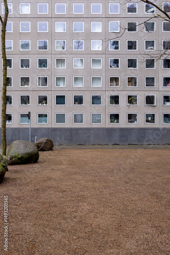 Modern building facade with repetitive square windows and central courtyard, ideal for copy space, architectural texture, and urban design themes in stock.