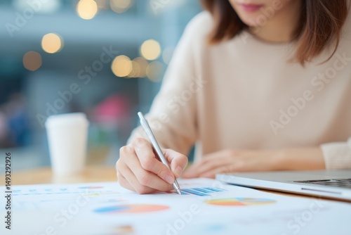 focused project manager working diligently at modern desk with minimalistic decor scouring charts and graphs