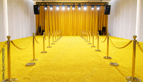 Yellow carpet runway with golden stanchions and velvet ropes leads to yellow curtain backdrop under bright stage lights, creating vibrant and elegant event space atmosphere