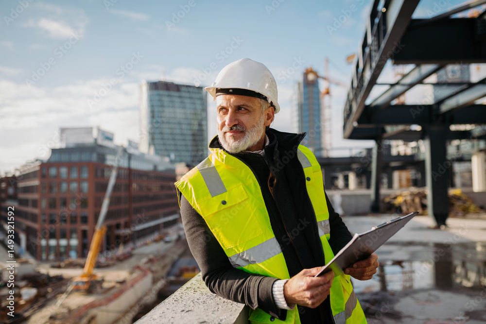 Engineer checking building documentation on clipboard at construction site. Engineer checking building documentation on clipboard at construction site.