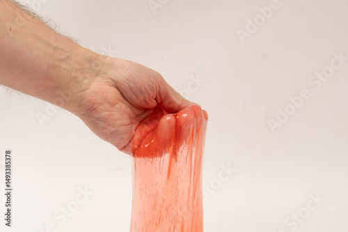 Wallpaper Mural Red slime toy in man hand isolated on white. Torontodigital.ca