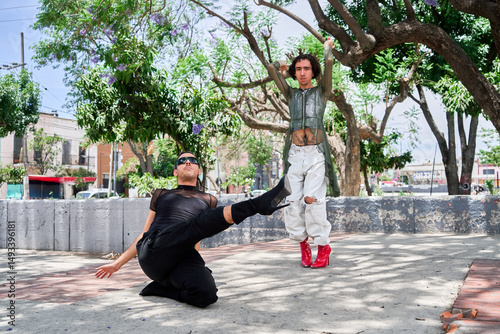 Two young LGBT dancers performing vogue choreography on city street
