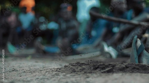 Senegalese Wrestling Ritual: Close-up Slow Motion of Hand Striking Ground with Stick, Vibrating Dust, Festive Atmosphere, Traditional Celebration