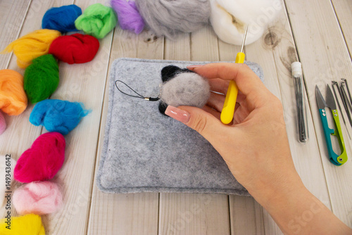Felting process with wool and tools. Handmade wool toys in progress. Perfect for craft projects, DIY, needle felting, and creative textile work.