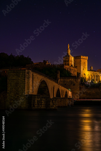 Avignon’s Pont Saint-Bénézet stands solemn over the Rhône, with the majestic Palais des Papes glowing above, echoing centuries of history beneath a velvet southern sky.