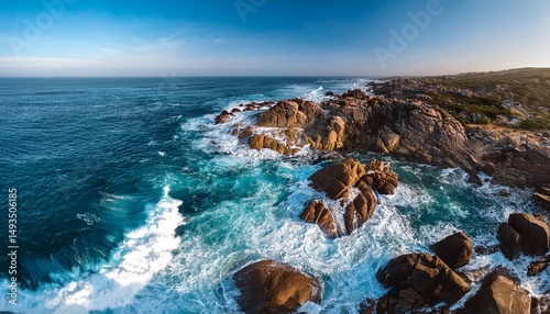 aerial perspective of rocky coastline with ocean waves crashing against the shore