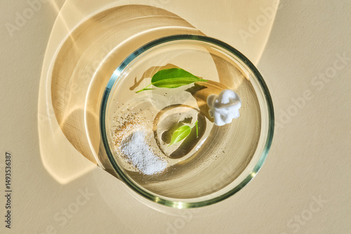 The texture of facial serum, cream and enzyme powder in a petri dish on a beige background.