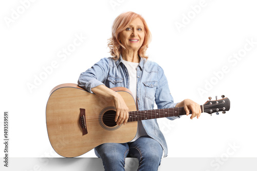 Woman sitting on a panel with an acoustic guitar photo