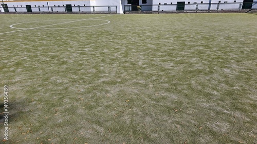 Worn Artificial Grass Soccer Field with Faded Lines and Sunlight
