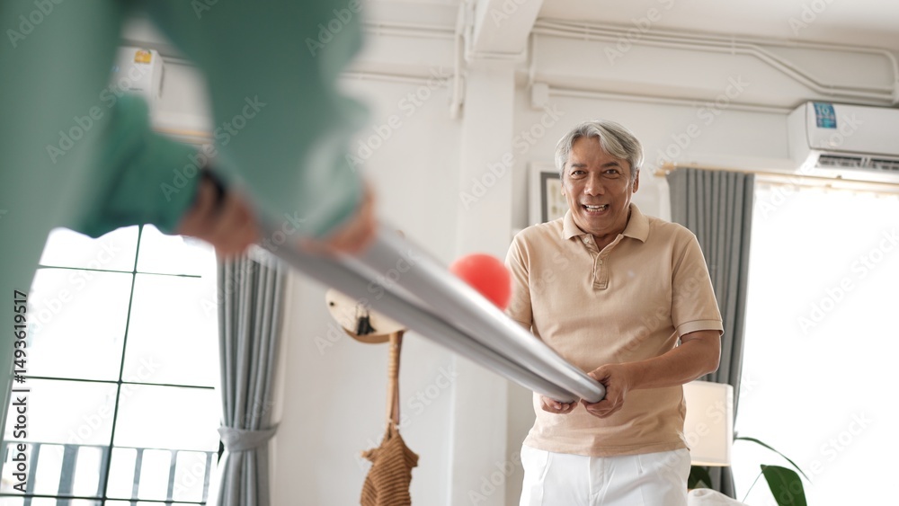 Obraz premium Grandfather holding pipe and carrying ball rolling game for exercise to improve eye, hand coordination or enhance focus and concentration. Elder couple providing stress relieve. Healthcare. Myrmidon.
