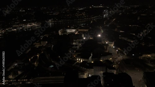 Drone orbits high over Porto side of Douro River at night with a view of Gaia in the distance