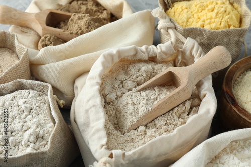 Different types of flour in bags on table, closeup