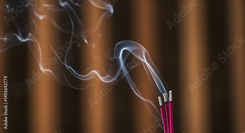 Incense Sticks Burning with Smoke Against Brown Background