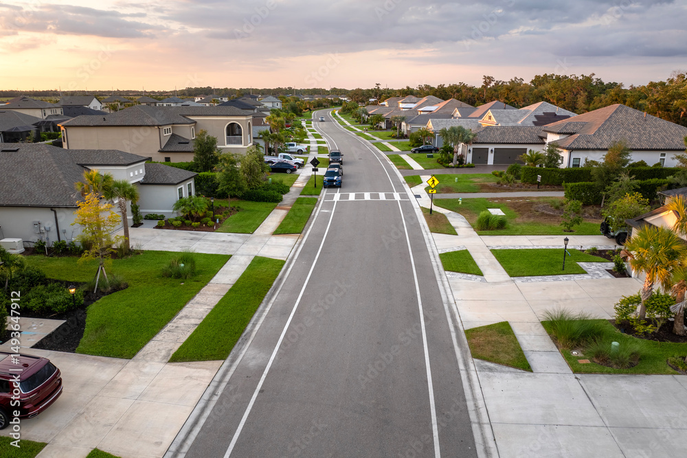 Fototapeta premium Expensive mansions between green palm trees in southwest Florida suburbs, USA. Aerial view of wealthy residential neighborhood
