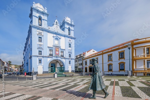 The striking blue and white facade of the Church of Mercy (Igreja da Misericordia) stands prominently in Angra do Heroismo, Terceira, Azores. Statue of an explorer Vasco de Gama graces the foreground
