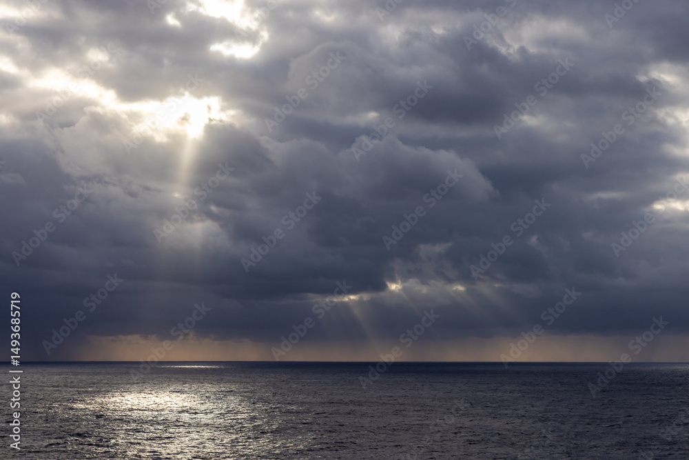 Obraz premium Dramatic Cloudscape Over The Pacific Ocean With Sun Rays Shining Through Clouds