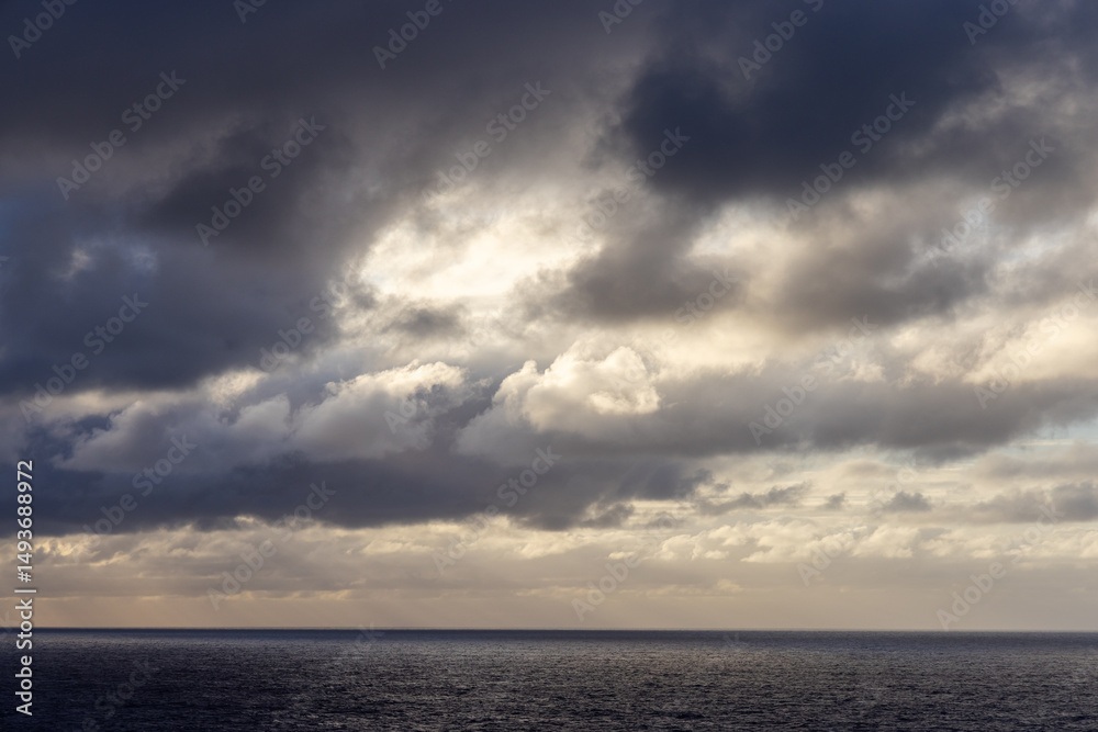Obraz premium Dramatic Cloudscape Over the Serene Pacific Ocean During Sunset