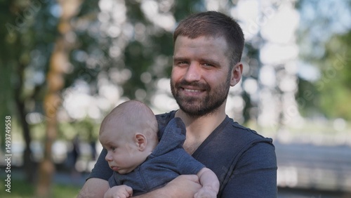Joyful father portrait with a small child in a summer park