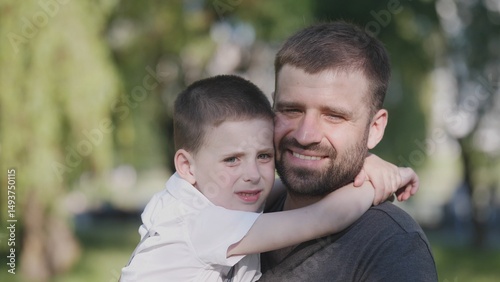 Joyful father portrait with a small child in a summer park